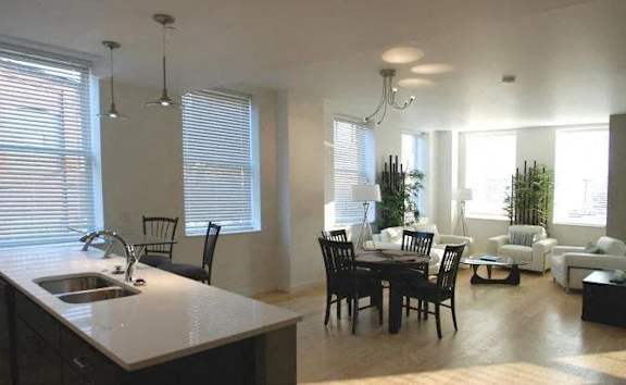 A kitchen with a dining table and chairs.