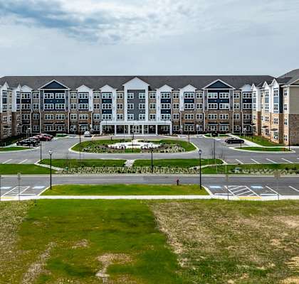 an exterior view of an apartment building with a parking lot