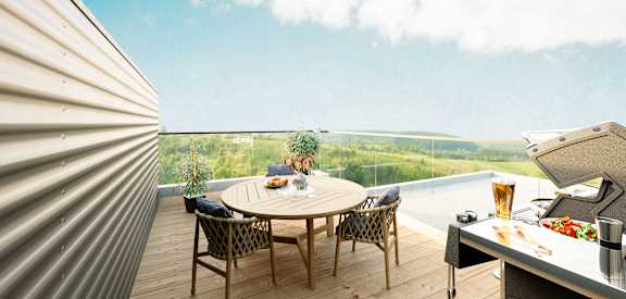 A table with chairs and a grill on a balcony overlooking a field.