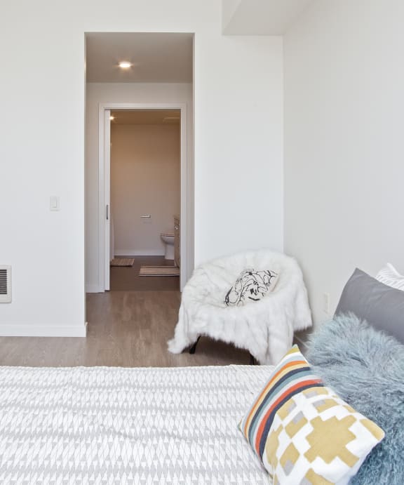 a bedroom with white walls and a bed with pillows