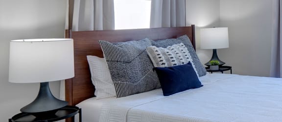 Bed With Pillows, Side Tables and Lamps. 