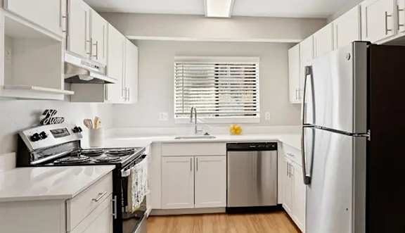 A white bathroom with a toilet, sink, and shower curtain.
