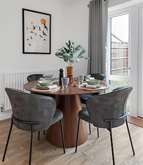A dining room with a table set for two and a potted plant on the table at The Woodlands Apartments, Milton Keynes, MK5 6GS
