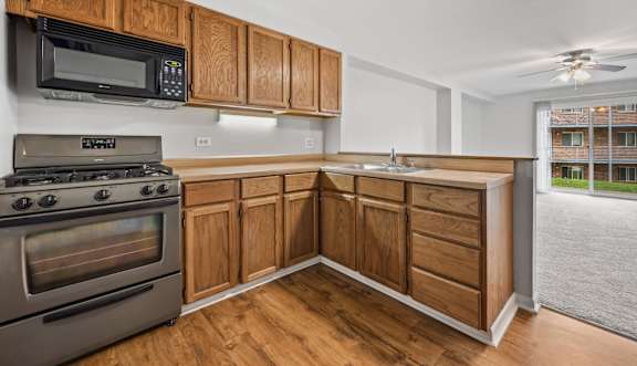 a kitchen with a stove a sink and a microwave at River Oaks, North Aurora, IL