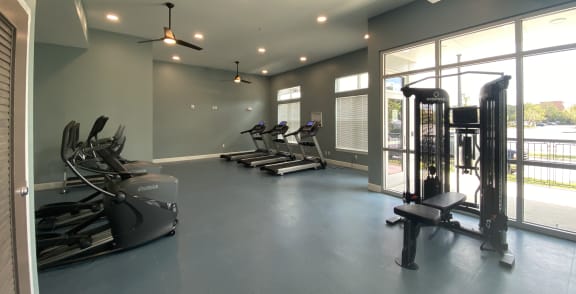 a gym with exercise equipment and windows in a building