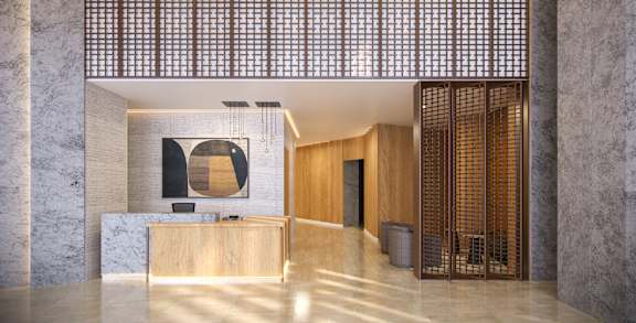 A reception area with a wooden counter and a large mirror above it.