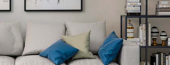 A modern living room with a white sofa, a coffee table, and two abstract paintings on the wall at The Heights Apartments, Montgomery, Alabama
