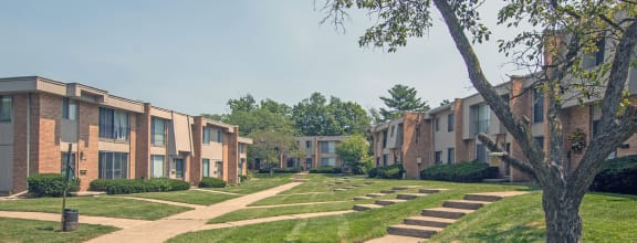 a pathway lined with apartment buildings on a sunny day