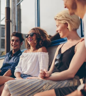 Group of Friends Sitting Outside of Building Smiling and Laughing