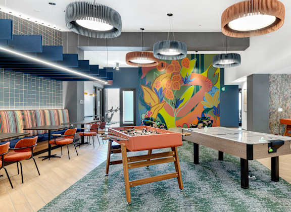 A room with a dining table and chairs.