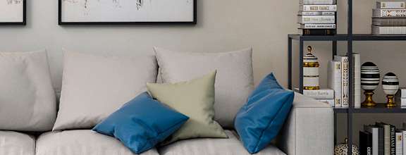 A modern living room with a white sofa, a coffee table, and two abstract paintings on the wall at Southaven Pointe Apartments, Southaven, MS