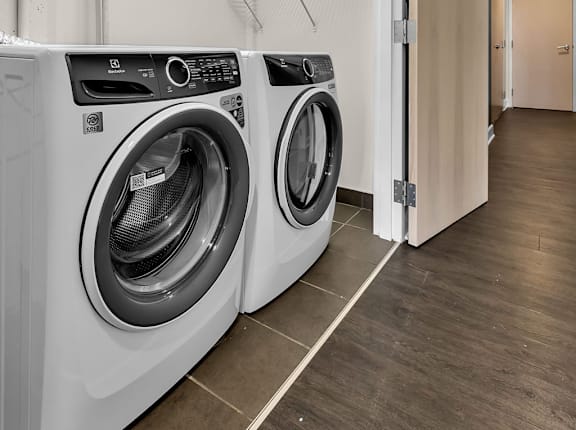 In unit laundry closet with front load washer and dryer at The Lofts at Elk Terminal Apartments, New York