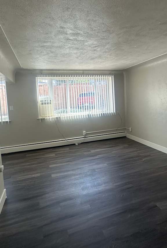 A hallway with a window and a door on the right side.
