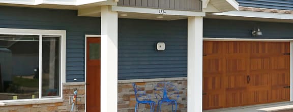 a house with a blue siding and a brown garage door
