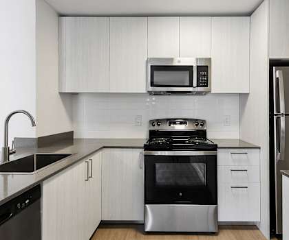 A modern kitchen with a stainless steel oven and microwave.