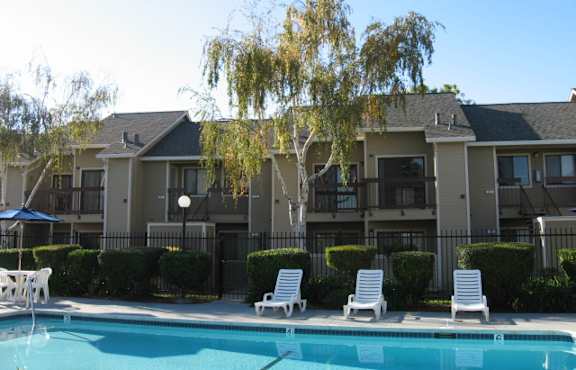 A swimming pool in front of apartment buildings.