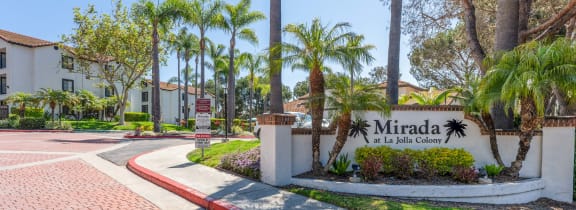 the entrance to mira la quinta apartments with palm trees