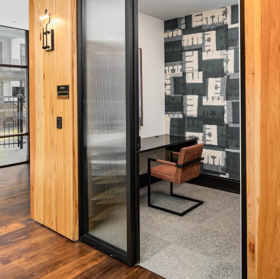 a glass door in a room with a desk and a chair at Abberly Foundry Apartment Homes, Nashville
