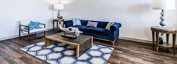 A living room with a blue couch and a wooden coffee table.