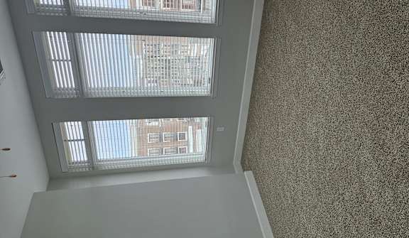 A room with a window overlooking a building.