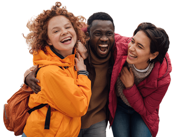 Three people wearing winter jackets are laughing together.