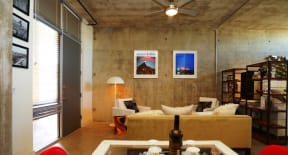 a living room with a couch and a table with a bottle of wine  at 1221 Broadway Lofts, San Antonio, Texas