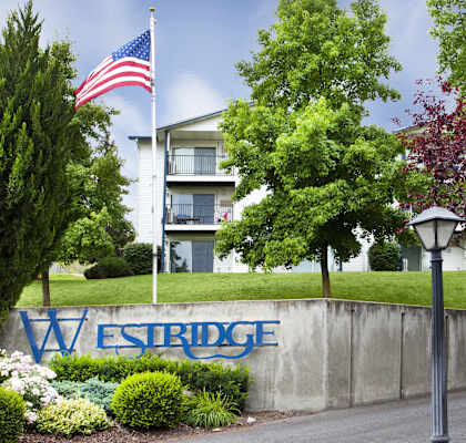Westridge Apartments Exterior Monument Sign with Flag Pole and Landscaping