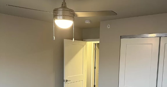 a living room with a ceiling light and a closet