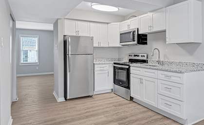 A kitchen with white cabinets and stainless steel appliances.