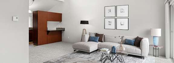 a living room with a couch a table and a ceiling fan