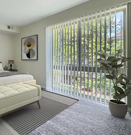 A bedroom with a large bed and a potted plant.