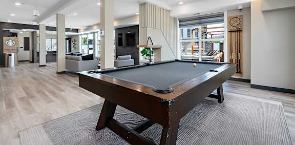 A pool table in a room with a striped wallpaper.