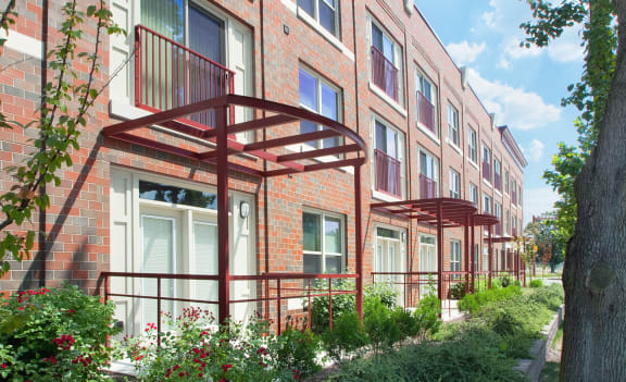 a row of brick apartment buildings with balconies and trees