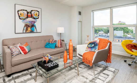 A living room with a couch, chair, and a painting on the wall.