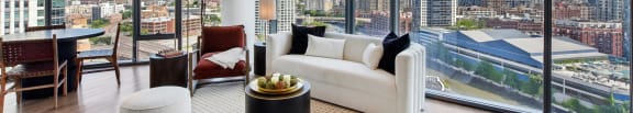 a living room with a view of the city and a white couch and a table at Cassidy on Canal, Chicago, Illinois
