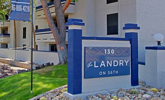 A street view of a residential area with a sign that reads "130 Landry on 56th".