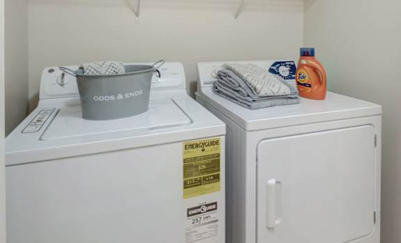Laundry room with two washing machines and a sign above them.