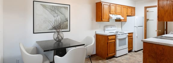 a kitchen and dining room with a table and chairs. Fargo, ND Brownstone Apartments
