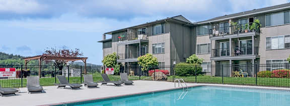 A swimming pool in front of apartment buildings.
