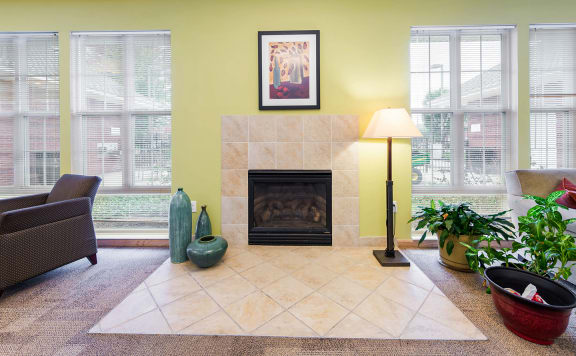 a community room with a fireplace and some windows at Horace Mann Apartments and Townhomes in Gary, IN