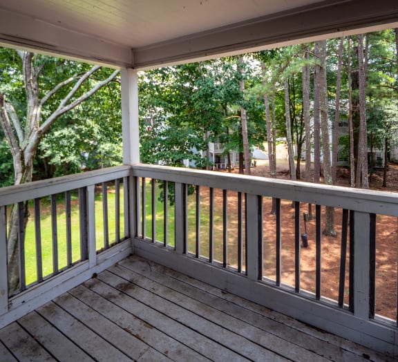 a large screened in porch with a view of the woods