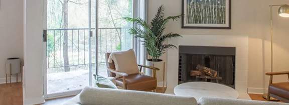 A living room with a grey couch and a fireplace.
