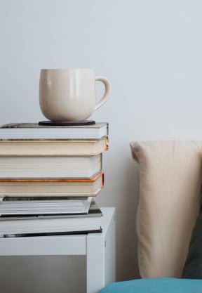 a cup of coffee on top of a stack of books at Preserve West, Madison, Wisconsin