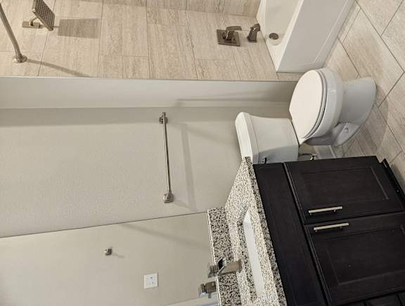A bathroom with a toilet, sink, and shower.