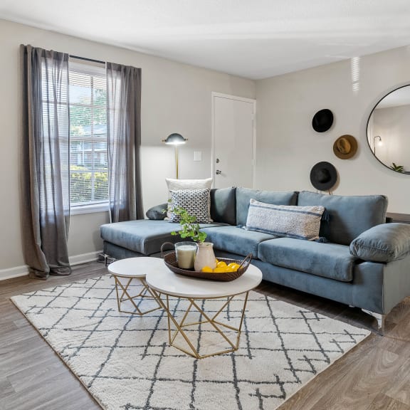 a living room with blue couches and chairs and a fireplace
