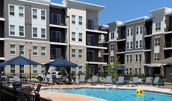 a swimming pool in front of an apartment building at One Deerfield, Mason