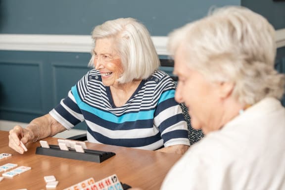 a group of seniors playing a board game at a table