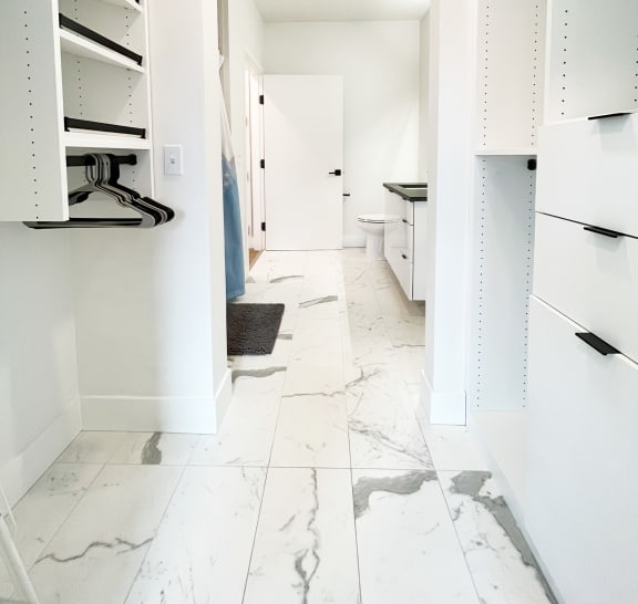 a walk in closet with white cabinets and a white marble floor  at Oslo, Washington