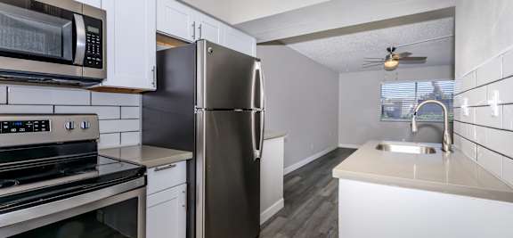 a kitchen with stainless steel appliances and white cabinets