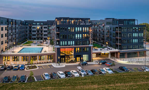 an aerial view of a building with a pool and parking lot